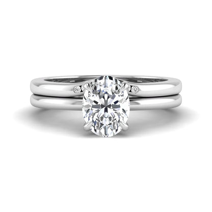 IGI certified oval cut lab grown diamond bridal ring set featuring a hidden halo engagement ring with a matching curved diamond wedding band in white gold.