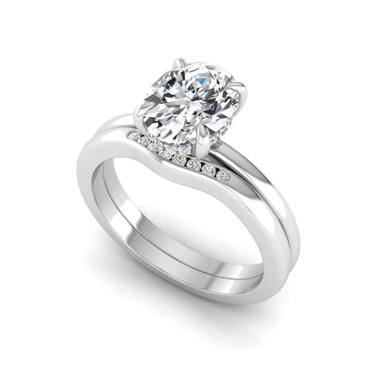 IGI certified oval cut lab grown diamond bridal ring set featuring a hidden halo engagement ring with a matching curved diamond wedding band in white gold.