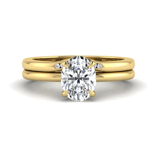 IGI certified oval cut lab grown diamond bridal ring set featuring a hidden halo engagement ring with a matching curved diamond wedding band in yellow gold.