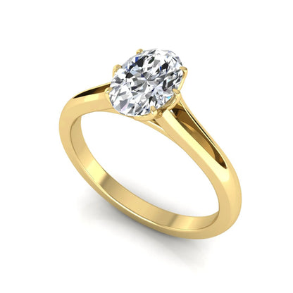 Oval cut lab grown diamond solitaire engagement ring featuring a four-prong setting and elegant split shank band in yellow gold tone.