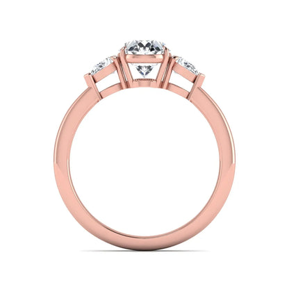 Oval cut lab grown diamond three stone engagement ring with pear cut side diamonds and prong setting in rose gold tone.