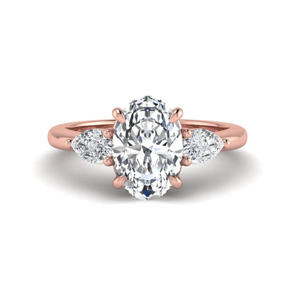 Oval cut three stone lab grown diamond engagement ring in rose gold featuring a 1.31 carat IGI certified center diamond with pear cut side diamonds.