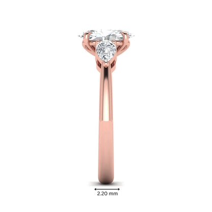Oval cut three stone lab grown diamond engagement ring in rose gold featuring a 1.31 carat IGI certified center diamond with pear cut side diamonds.
