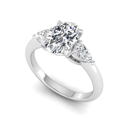 Oval cut three stone lab grown diamond engagement ring in white gold featuring a 1.31 carat IGI certified center diamond with pear cut side diamonds.
