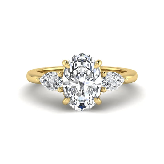 Oval cut three stone lab grown diamond engagement ring in yellow gold featuring a 1.31 carat IGI certified center diamond with pear cut side diamonds.