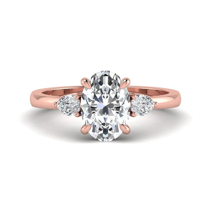 Oval cut lab grown diamond three stone engagement ring with pear side diamonds in rose gold.