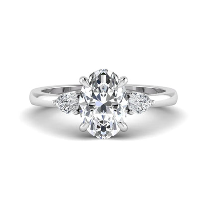 Oval cut lab grown diamond three stone engagement ring with pear side diamonds in white gold.