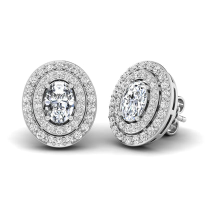 Oval cut lab grown diamond stud earrings featuring a double halo of round cut diamonds, prong setting, push back closure, and white gold tone design.