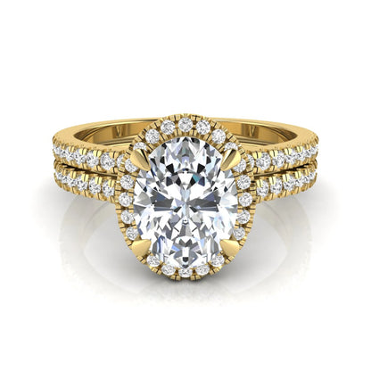 Oval cut lab grown diamond bridal ring set featuring an IGI certified center diamond with a round diamond halo and matching pavé wedding band in yellow gold