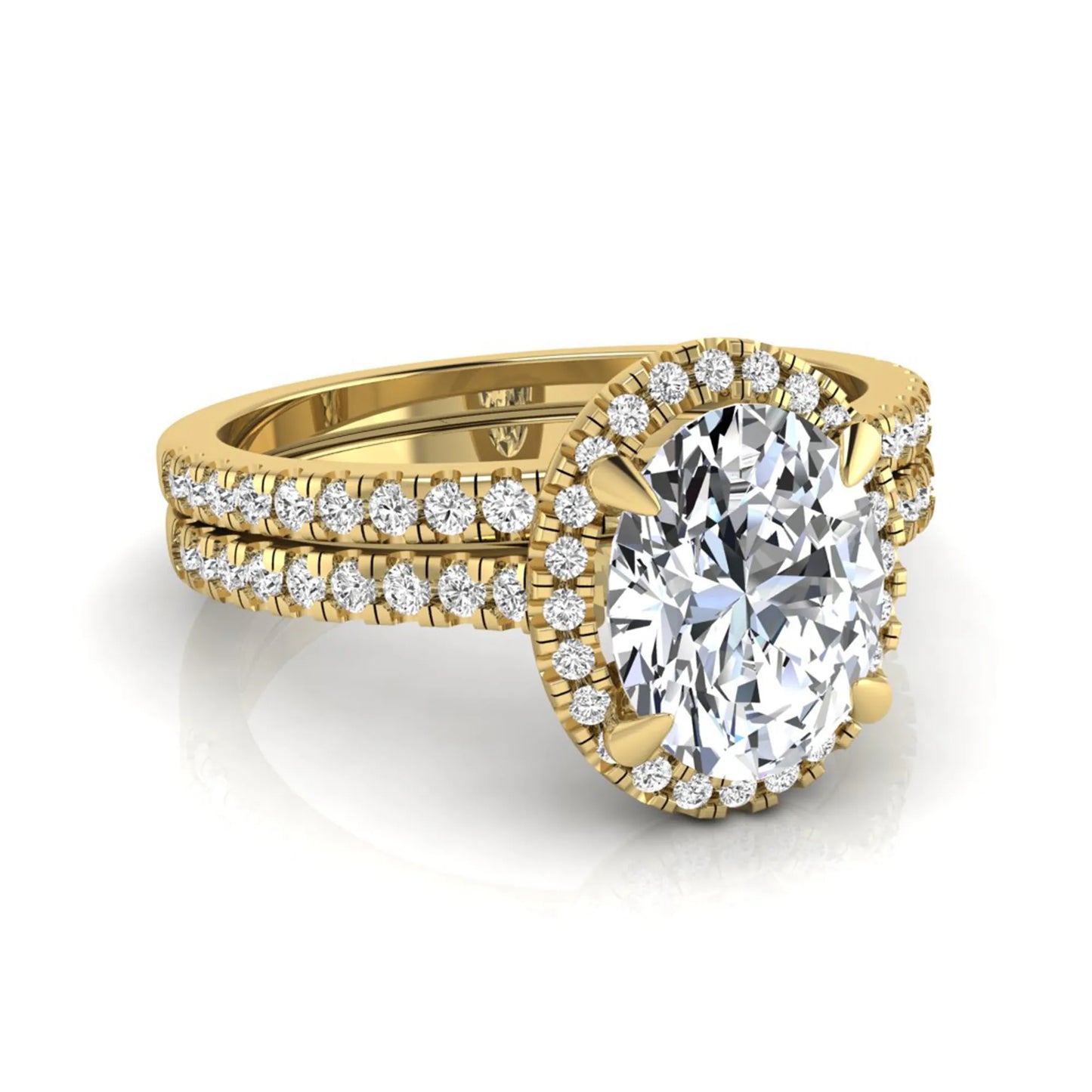 Oval cut lab grown diamond bridal ring set featuring an IGI certified center diamond with a round diamond halo and matching pavé wedding band in yellow gold
