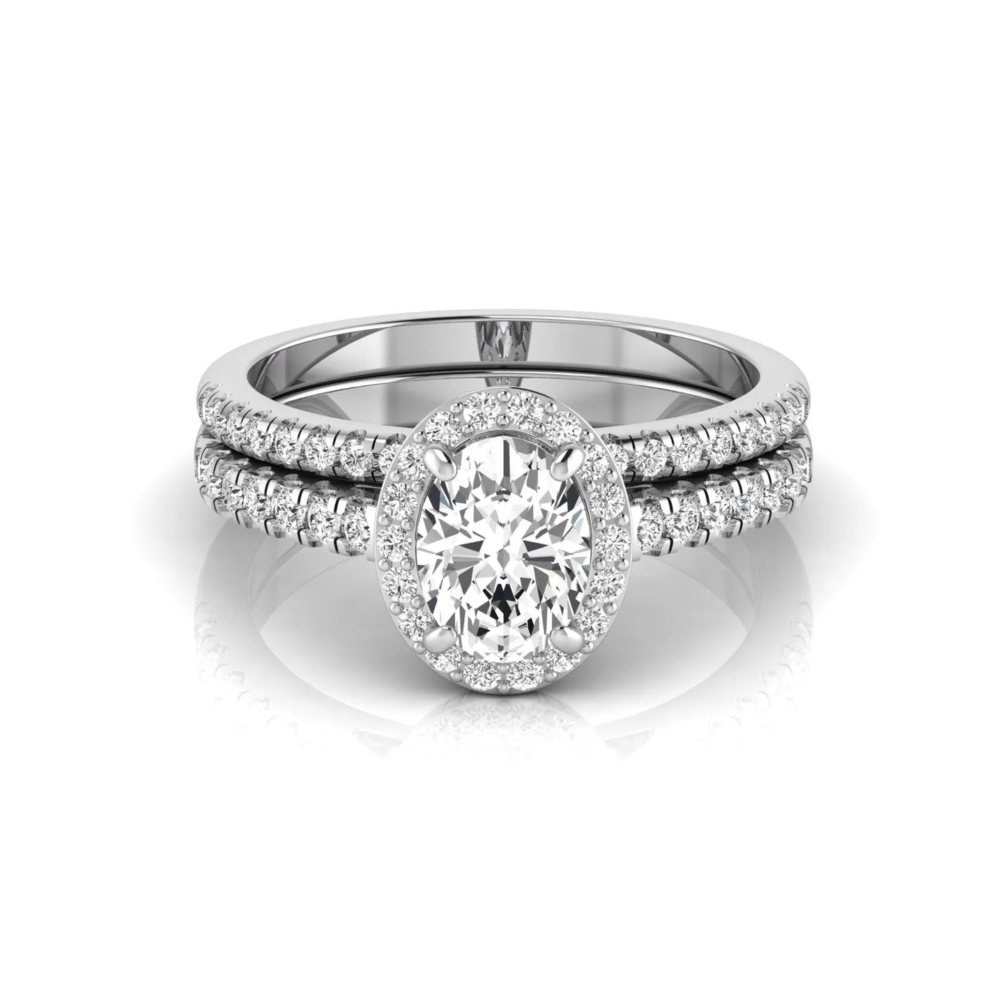 Oval halo lab grown diamond bridal ring set featuring an IGI certified oval cut center diamond with round pavé diamonds in a classic halo setting and matching wedding band in white gold