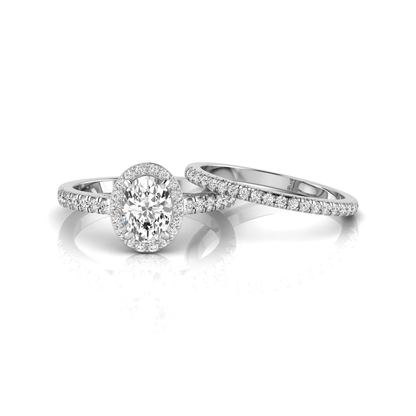 Oval halo lab grown diamond bridal ring set featuring an IGI certified oval cut center diamond with round pavé diamonds in a classic halo setting and matching wedding band in white gold