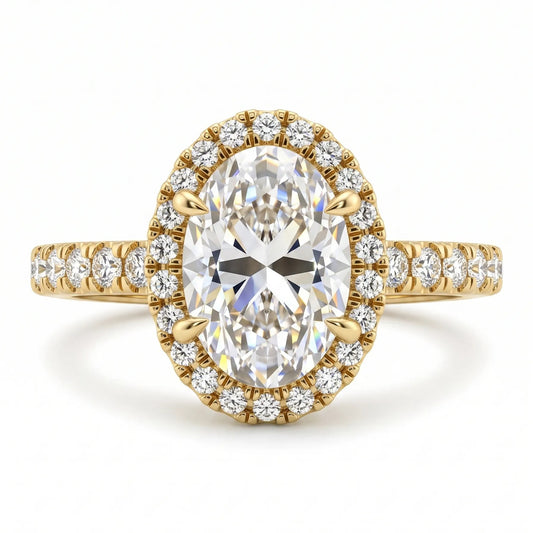 A yellow gold oval halo engagement ring featuring a large oval center diamond surrounded by a double row of small round diamonds, with a diamond-set band on a clean white background.