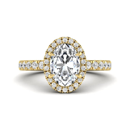 Oval cut lab grown diamond halo engagement ring with pavé round diamonds in a yellow gold setting