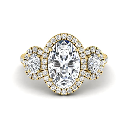 Oval cut lab grown diamond three stone engagement ring featuring a halo center, halo oval side diamonds, pavé shoulders, and a polished yellow gold tone band.
