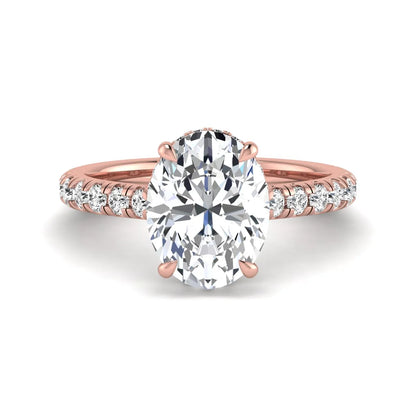 Oval cut lab grown diamond hidden halo engagement ring with pavé band and four-prong setting in a rose gold tone design.