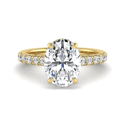 Oval cut lab grown diamond hidden halo engagement ring with pavé band and four-prong setting in a yellow gold tone design.