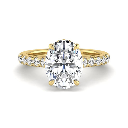Oval cut lab grown diamond hidden halo engagement ring with pavé band and four-prong setting in a yellow gold tone design.