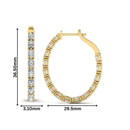 Oval cut lab grown diamond inside-out hoop earrings featuring shared prong settings, hinged snap closure, and yellow gold tone design.