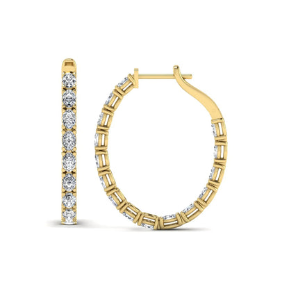 Oval cut lab grown diamond inside-out hoop earrings featuring shared prong settings, hinged snap closure, and yellow gold tone design.