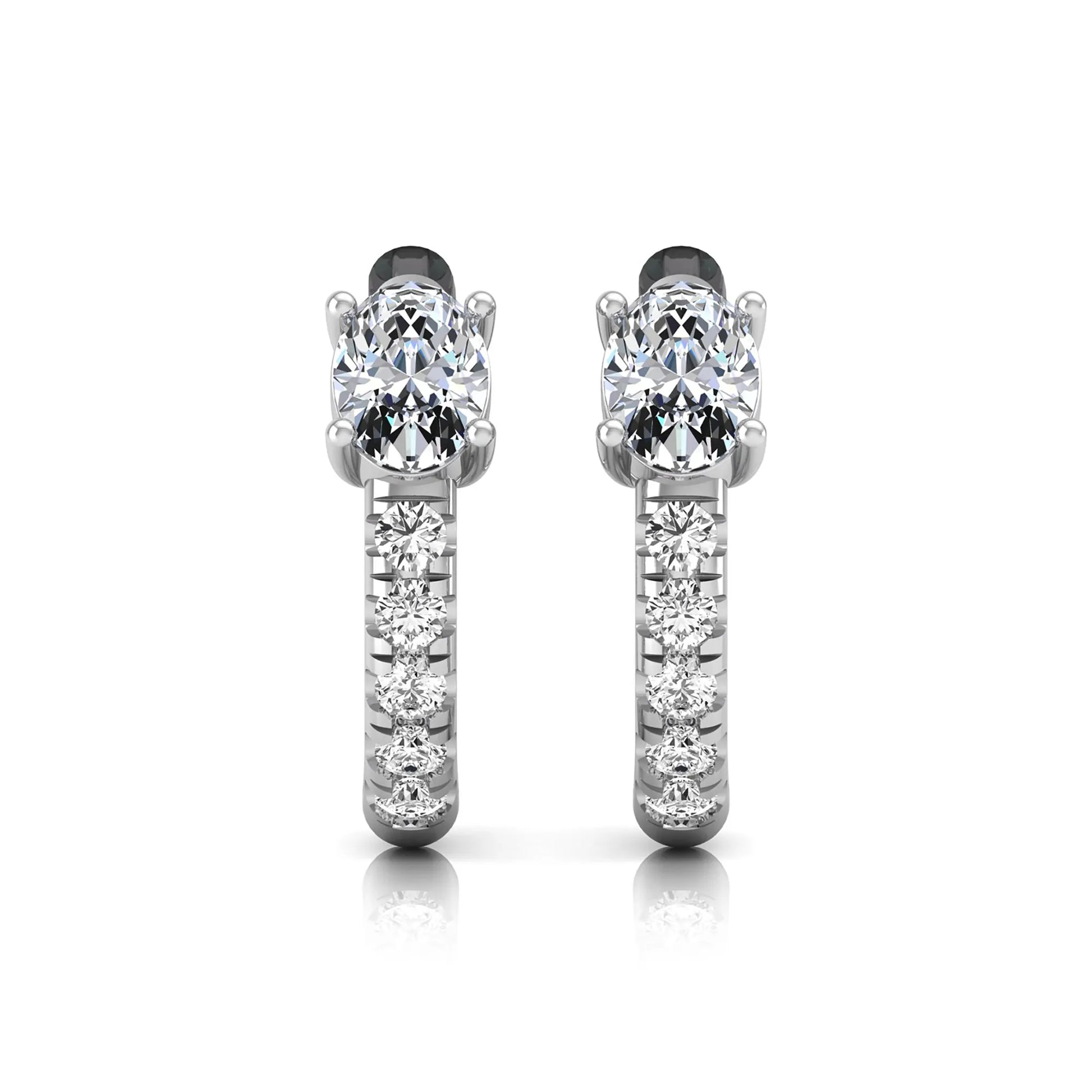 Oval cut lab grown diamond huggie hoop earrings featuring a four prong basket set center diamond with graduated round brilliant pavé diamonds on a white gold hoop.
