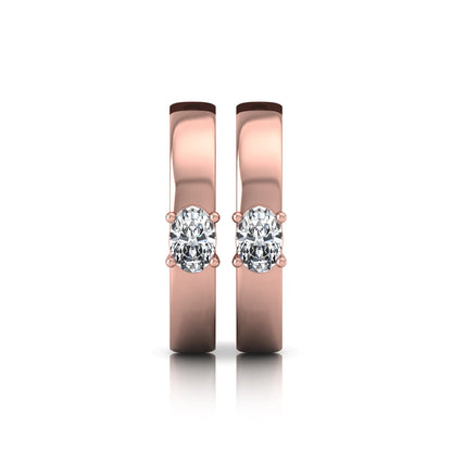 Oval cut lab grown diamond huggie hoop earrings featuring a classic four prong setting and hinged snap closure shown in rose gold tone with a polished finish.
