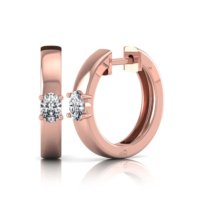Oval cut lab grown diamond huggie hoop earrings featuring a classic four prong setting and hinged snap closure shown in rose gold tone with a polished finish.