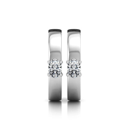 Oval cut lab grown diamond huggie hoop earrings featuring a classic four prong setting and hinged snap closure shown in white gold tone with a polished finish.