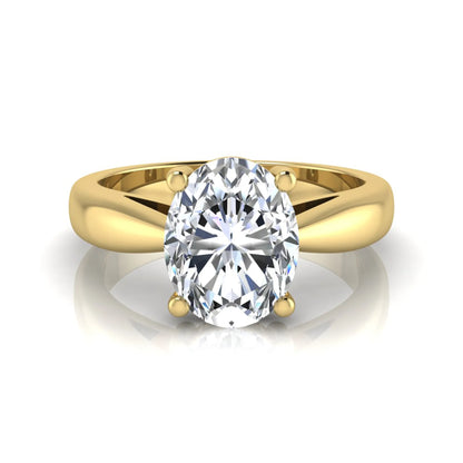 Oval cut lab grown diamond solitaire engagement ring with a four prong setting and yellow gold tone band.