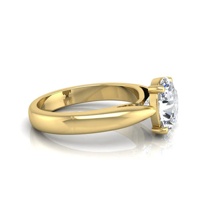 Oval cut lab grown diamond solitaire engagement ring with a four prong setting and yellow gold tone band.