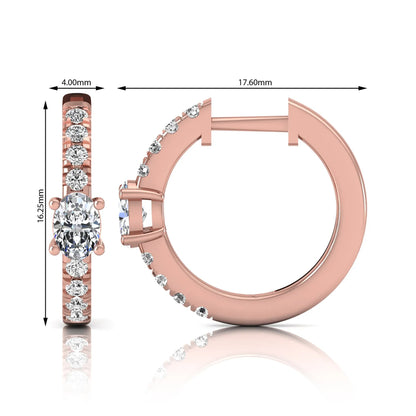 Oval and round lab grown diamond pavé huggie hoop earrings featuring a four prong oval center diamond with graduated shared prong round diamond accents in rose gold.