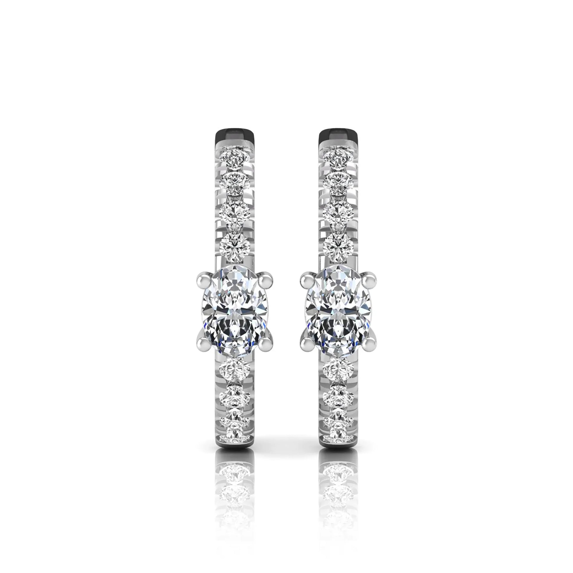 Oval and round lab grown diamond pavé huggie hoop earrings featuring a four prong oval center diamond with graduated shared prong round diamond accents in white gold.