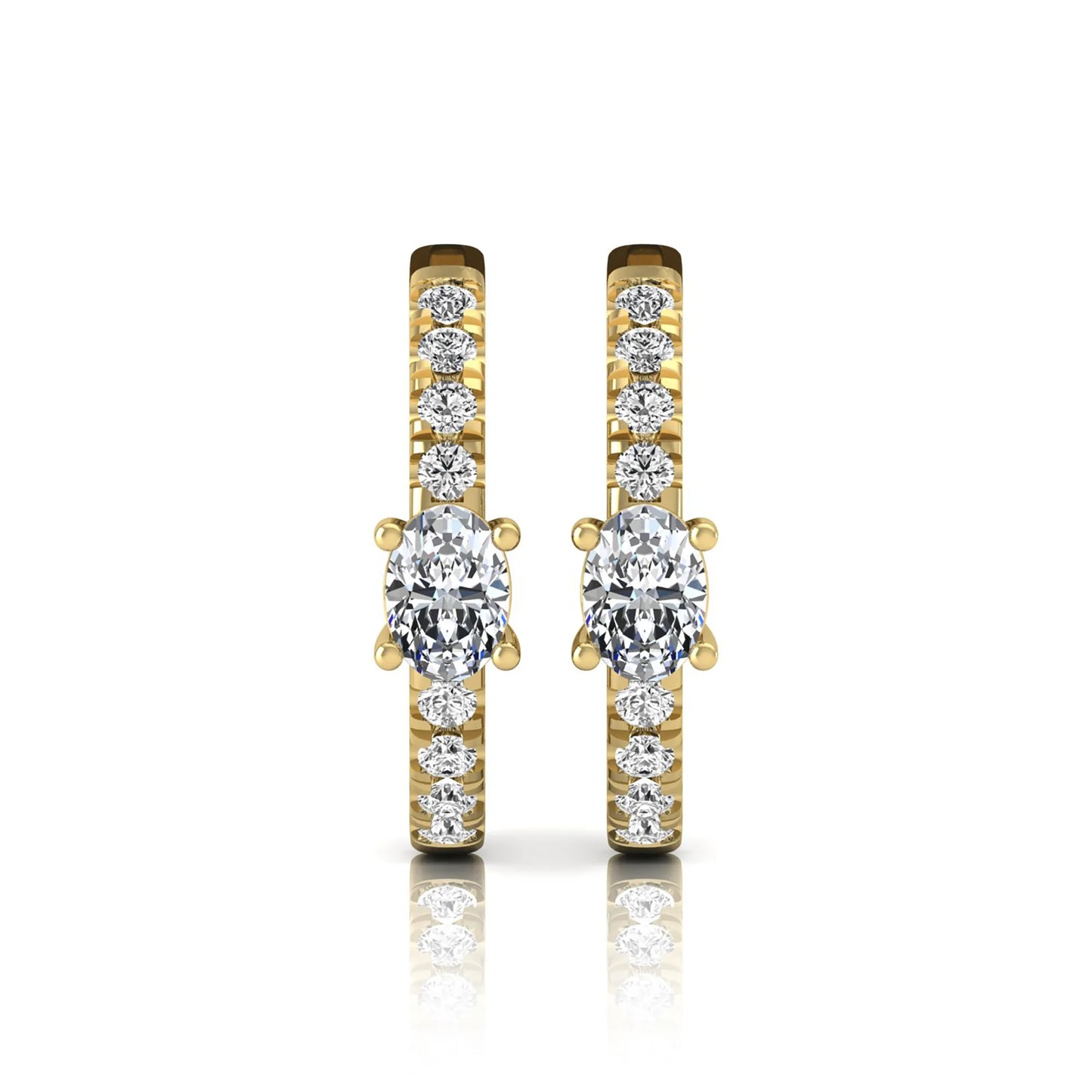 Oval and round lab grown diamond pavé huggie hoop earrings featuring a four prong oval center diamond with graduated shared prong round diamond accents in yellow gold.