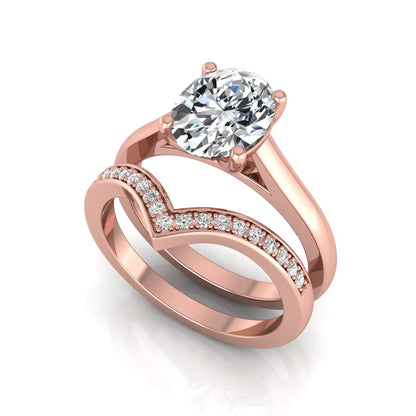 Oval cut lab grown diamond bridal ring set featuring a four-prong solitaire engagement ring with a pavé chevron V-shaped wedding band in a rose gold finish.
