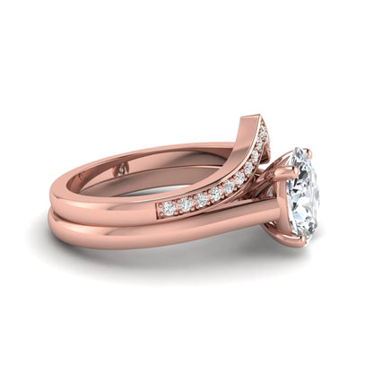 Oval cut lab grown diamond bridal ring set featuring a four-prong solitaire engagement ring with a pavé chevron V-shaped wedding band in a rose gold finish.