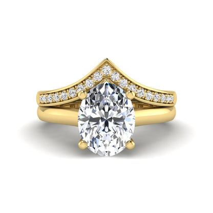 Oval cut lab grown diamond bridal ring set featuring a four-prong solitaire engagement ring with a pavé chevron V-shaped wedding band in a yellow gold finish.