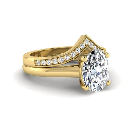 Oval cut lab grown diamond bridal ring set featuring a four-prong solitaire engagement ring with a pavé chevron V-shaped wedding band in a yellow gold finish.