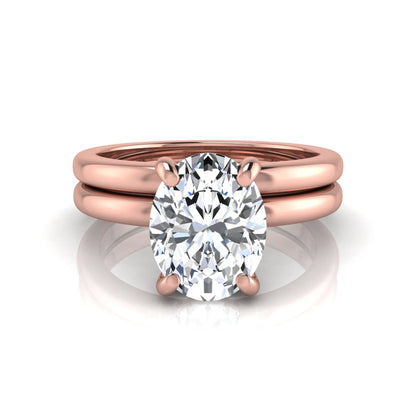 Oval cut lab grown diamond solitaire engagement ring with a matching plain gold wedding band in rose gold