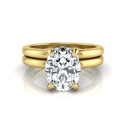 Oval cut lab grown diamond solitaire engagement ring with a matching plain gold wedding band in yellow gold