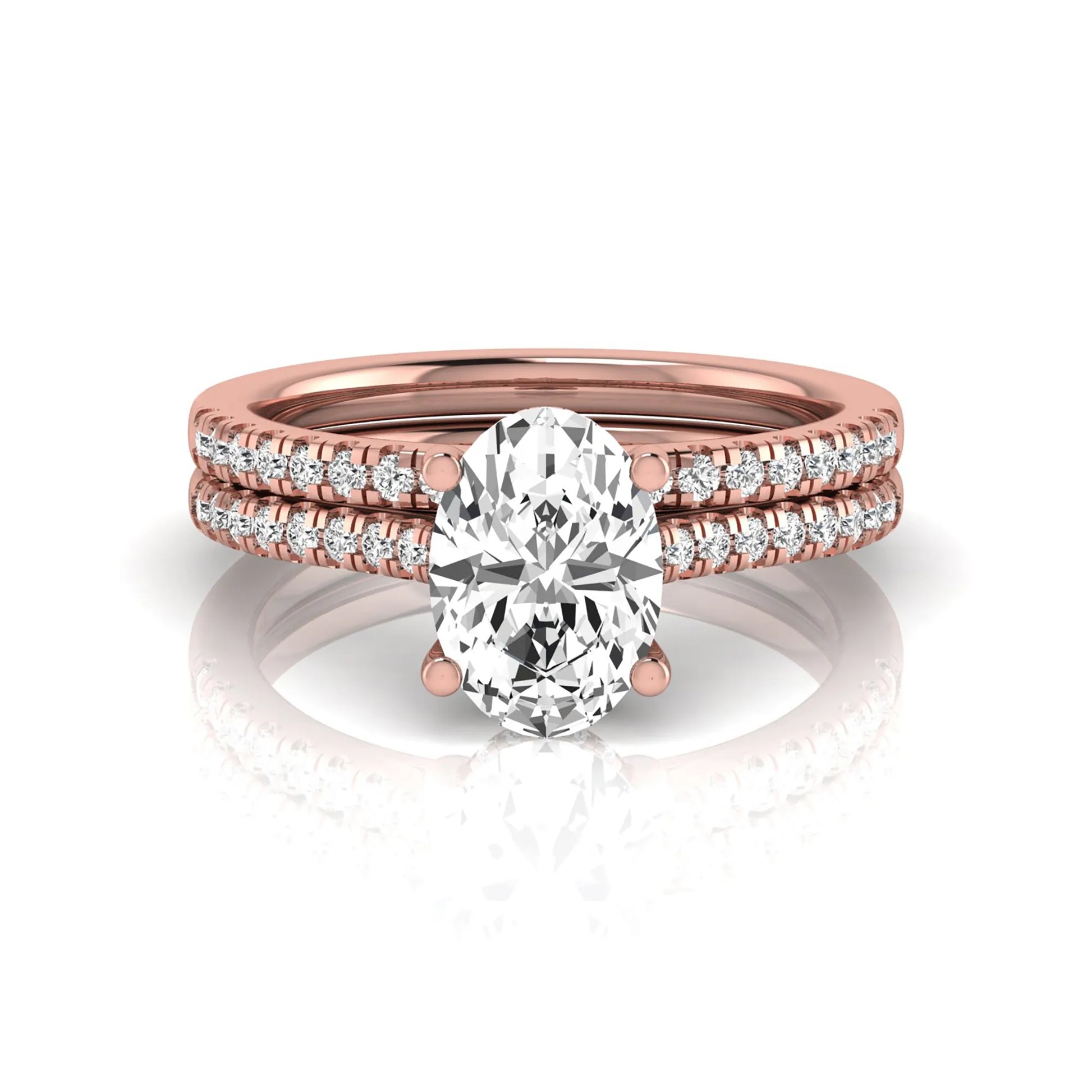 Oval cut lab grown diamond solitaire bridal ring set featuring a four-prong center diamond with pavé diamond engagement ring and matching pavé wedding band in rose gold tone.