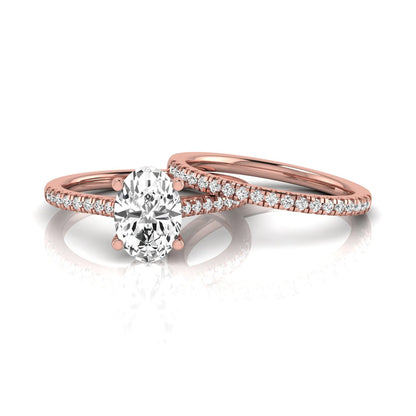 Oval cut lab grown diamond solitaire bridal ring set featuring a four-prong center diamond with pavé diamond engagement ring and matching pavé wedding band in rose gold tone.