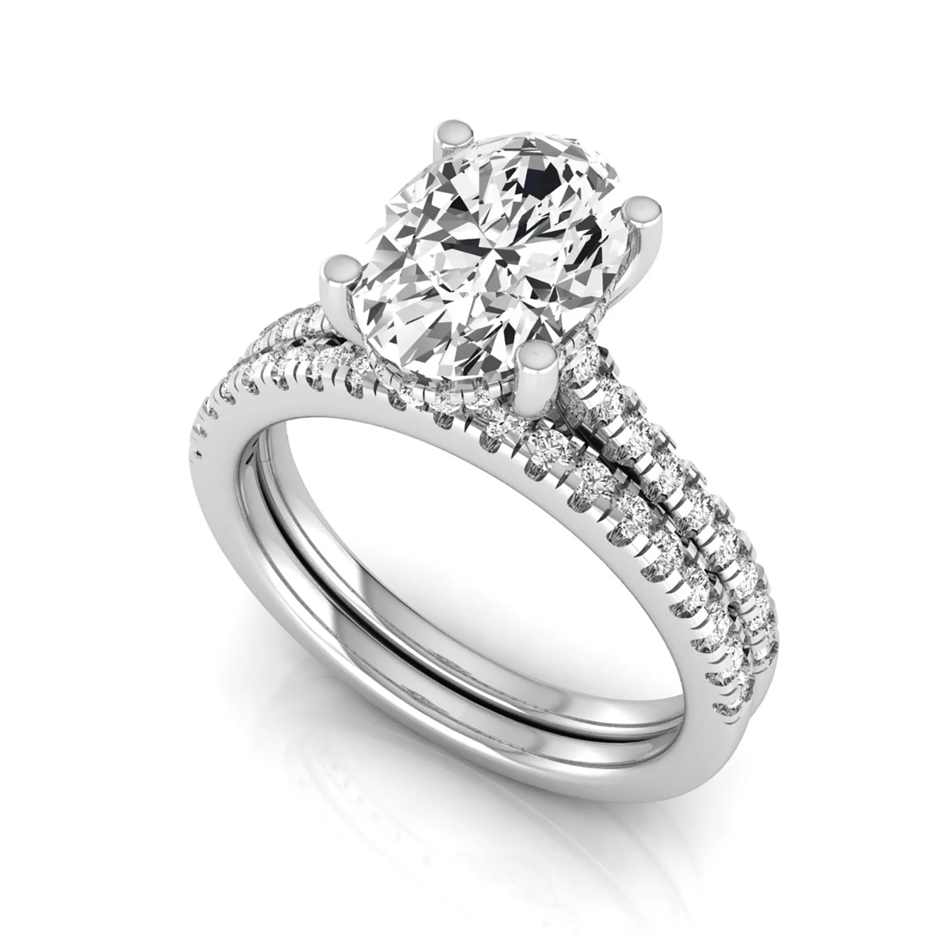 Oval cut lab grown diamond solitaire bridal ring set featuring a four-prong center diamond with pavé diamond engagement ring and matching pavé wedding band in white gold tone.
