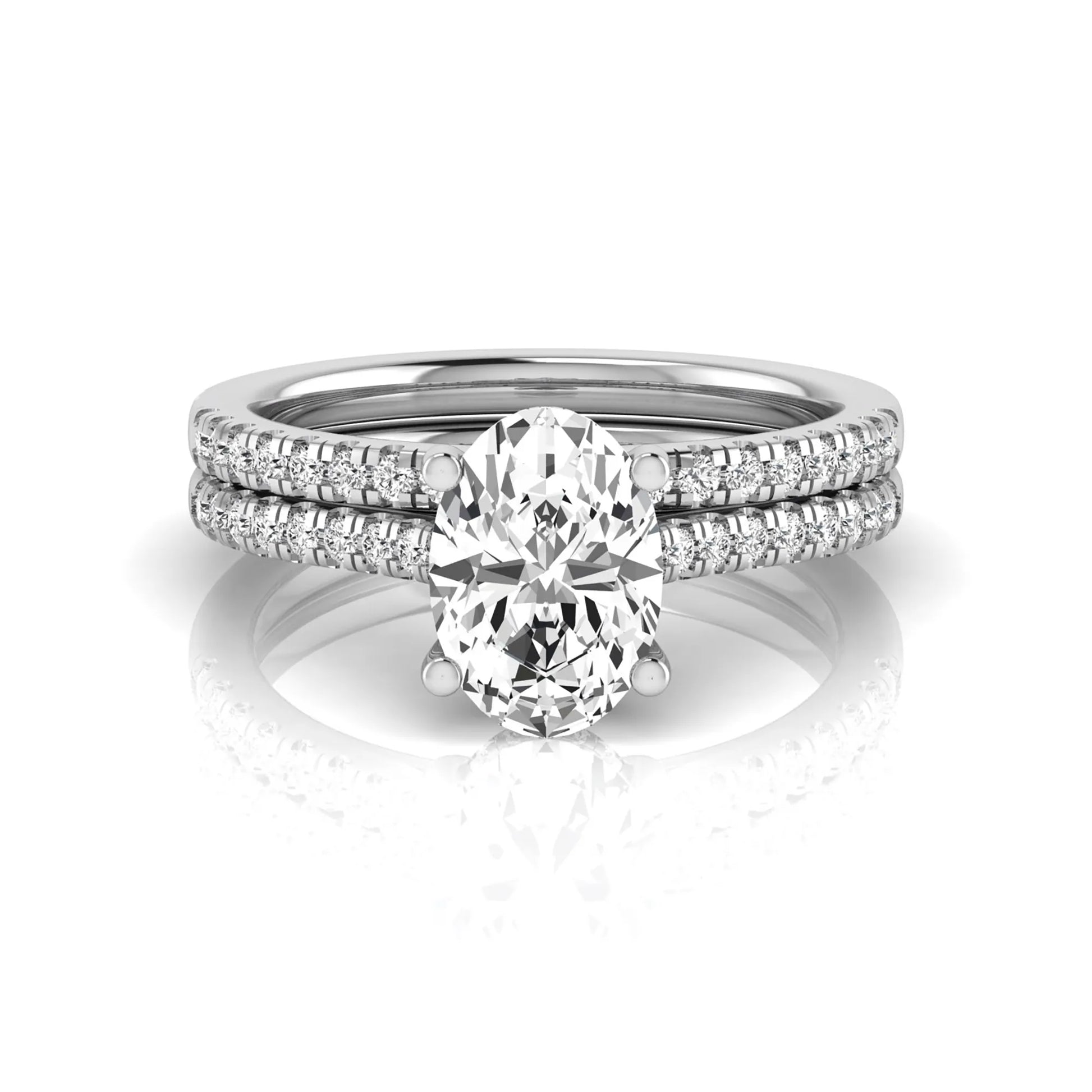 Oval cut lab grown diamond solitaire bridal ring set featuring a four-prong center diamond with pavé diamond engagement ring and matching pavé wedding band in white gold tone.