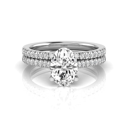 Oval cut lab grown diamond solitaire bridal ring set featuring a four-prong center diamond with pavé diamond engagement ring and matching pavé wedding band in white gold tone.