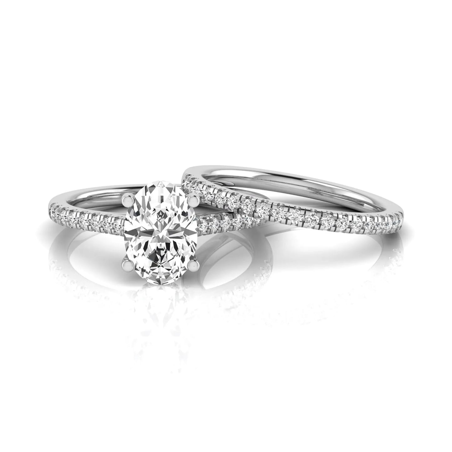 Oval cut lab grown diamond solitaire bridal ring set featuring a four-prong center diamond with pavé diamond engagement ring and matching pavé wedding band in white gold tone.