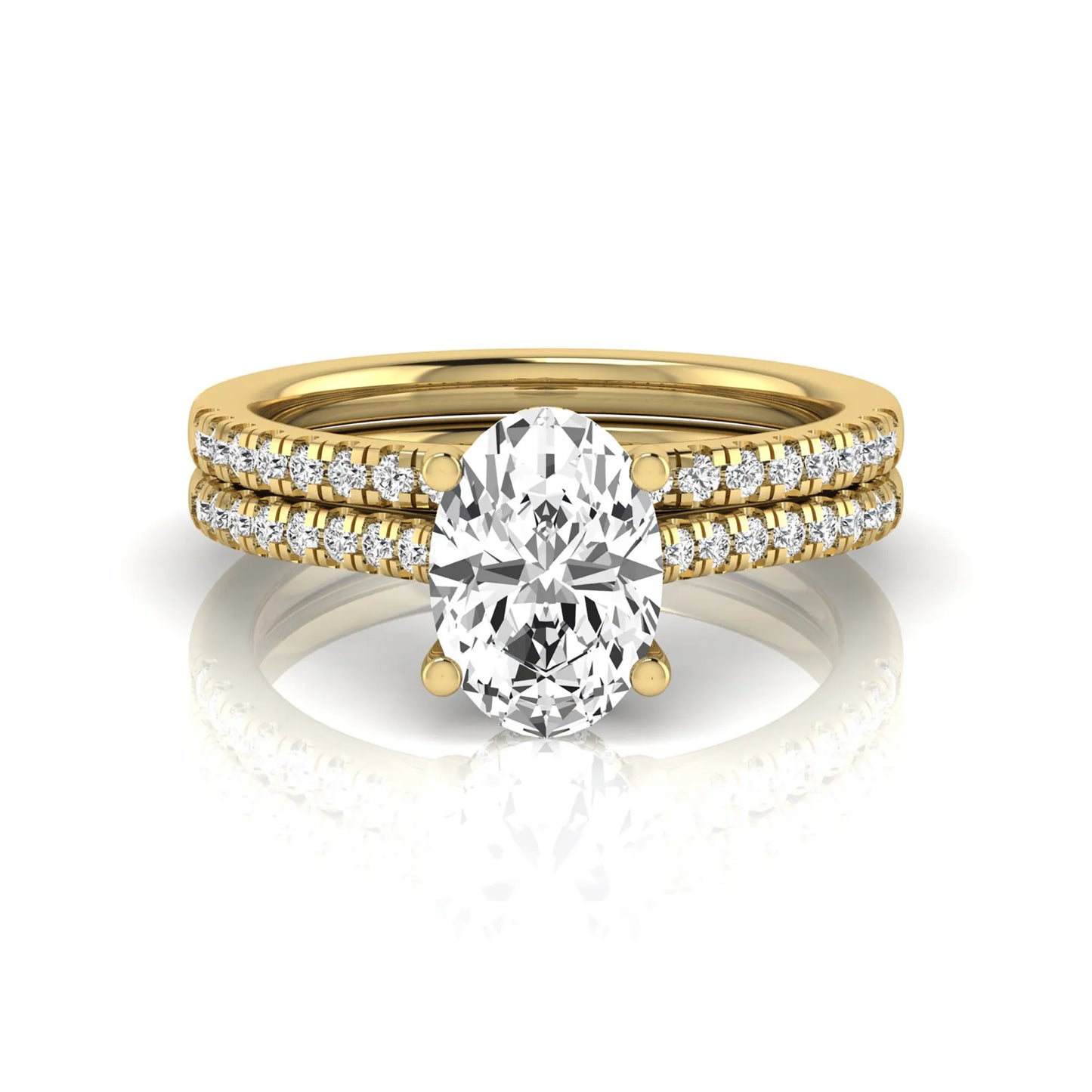 Oval cut lab grown diamond solitaire bridal ring set featuring a four-prong center diamond with pavé diamond engagement ring and matching pavé wedding band in yellow gold tone.