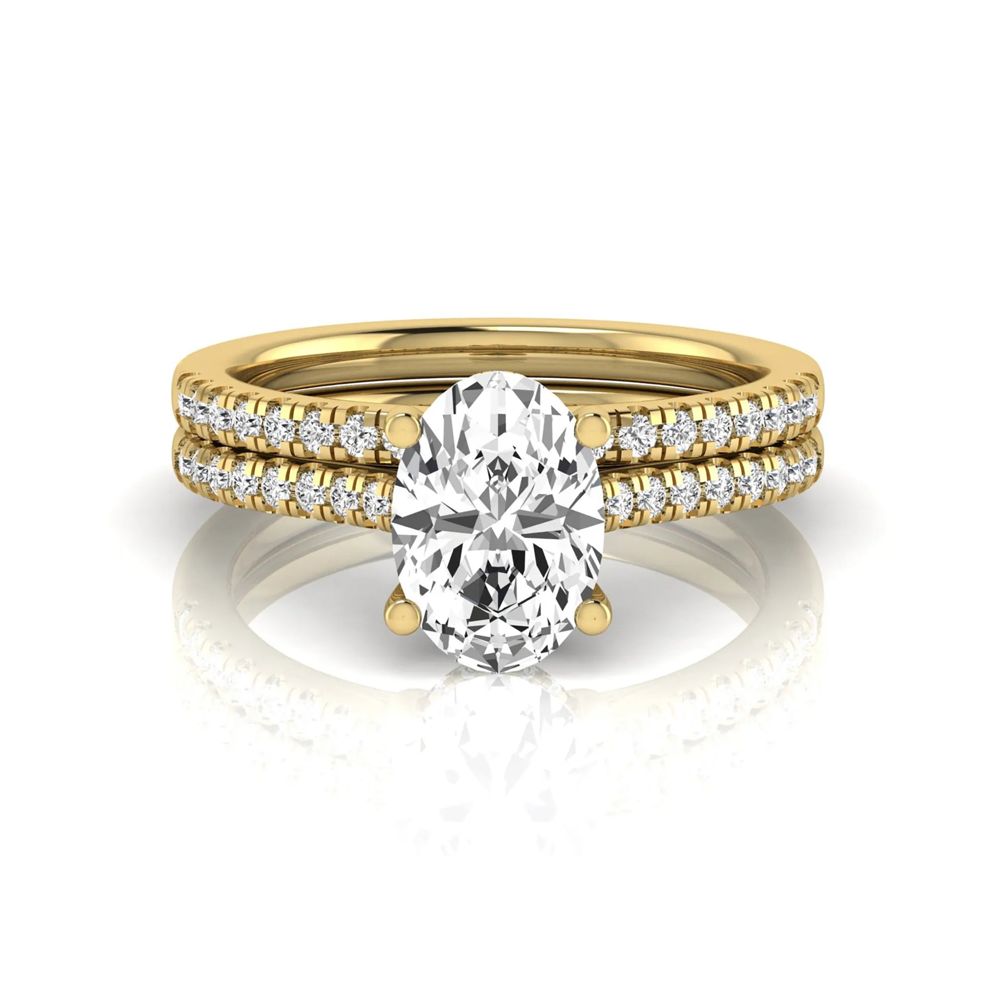 Oval cut lab grown diamond solitaire bridal ring set featuring a four-prong center diamond with pavé diamond engagement ring and matching pavé wedding band in yellow gold tone.
