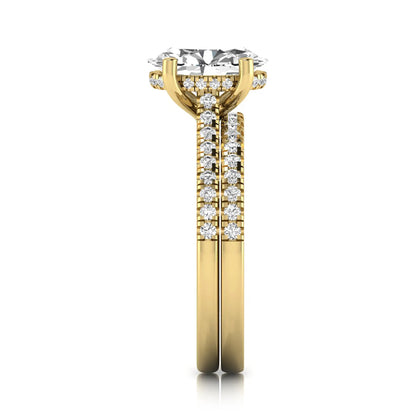 Oval cut lab grown diamond solitaire bridal ring set featuring a four-prong center diamond with pavé diamond engagement ring and matching pavé wedding band in yellow gold tone.