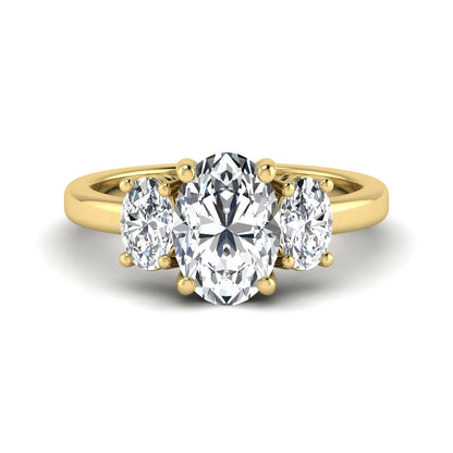 Oval cut three stone lab grown diamond engagement ring featuring an IGI certified center diamond with matching oval side diamonds in yellow gold.