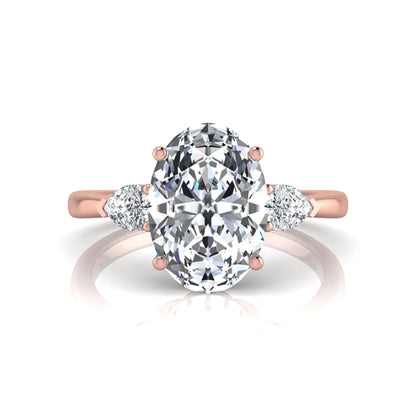 Oval three stone lab grown diamond engagement ring featuring a 1.86 carat IGI certified oval cut center diamond with pear cut side diamonds in a rose gold design.